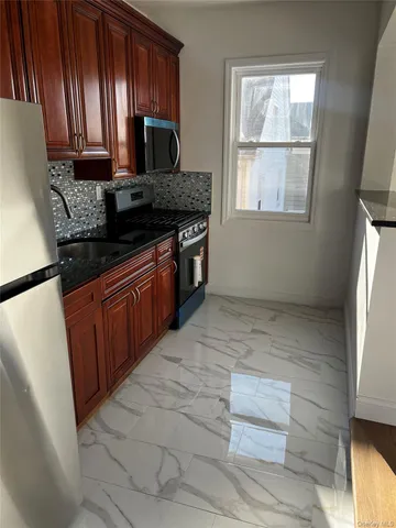 a kitchen with stainless steel appliances granite countertop a stove a sink and a refrigerator