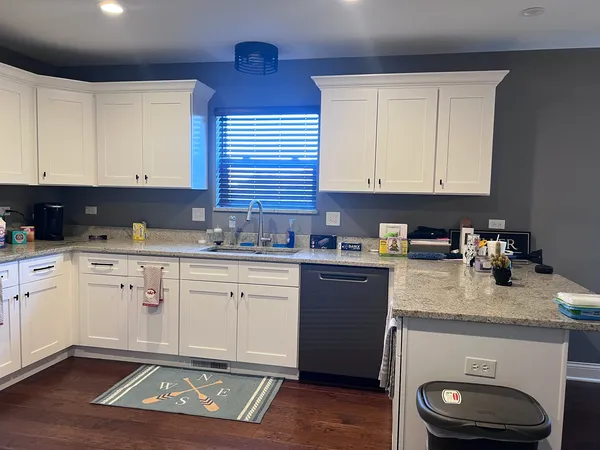 a kitchen with granite countertop a sink a stove and cabinets
