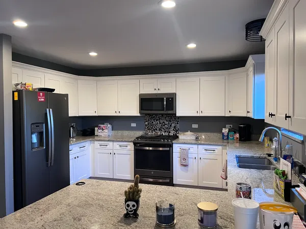 a kitchen with a refrigerator a stove top oven a sink and dishwasher