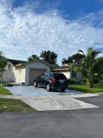a view of a car is parked in front of a brick house