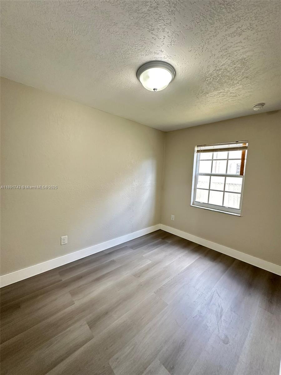3611 Northwest 194th Terrace Miami Gardens, FL 33056 - Photo 11 of 15 an empty room with wooden floor and windows