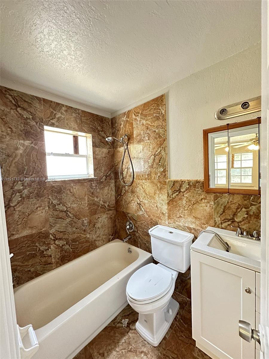 3611 Northwest 194th Terrace Miami Gardens, FL 33056 - Photo 14 of 15 a bathroom with a toilet a sink and a bathtub