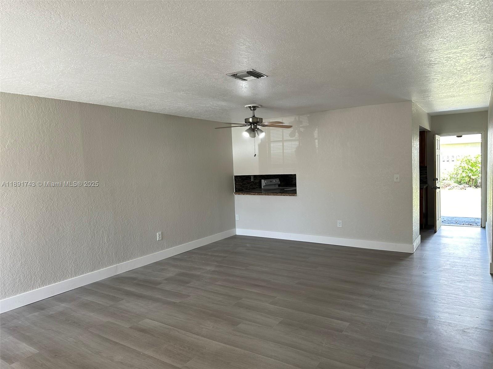 3611 Northwest 194th Terrace Miami Gardens, FL 33056 - Photo 6 of 15 wooden floor in an empty room with a window
