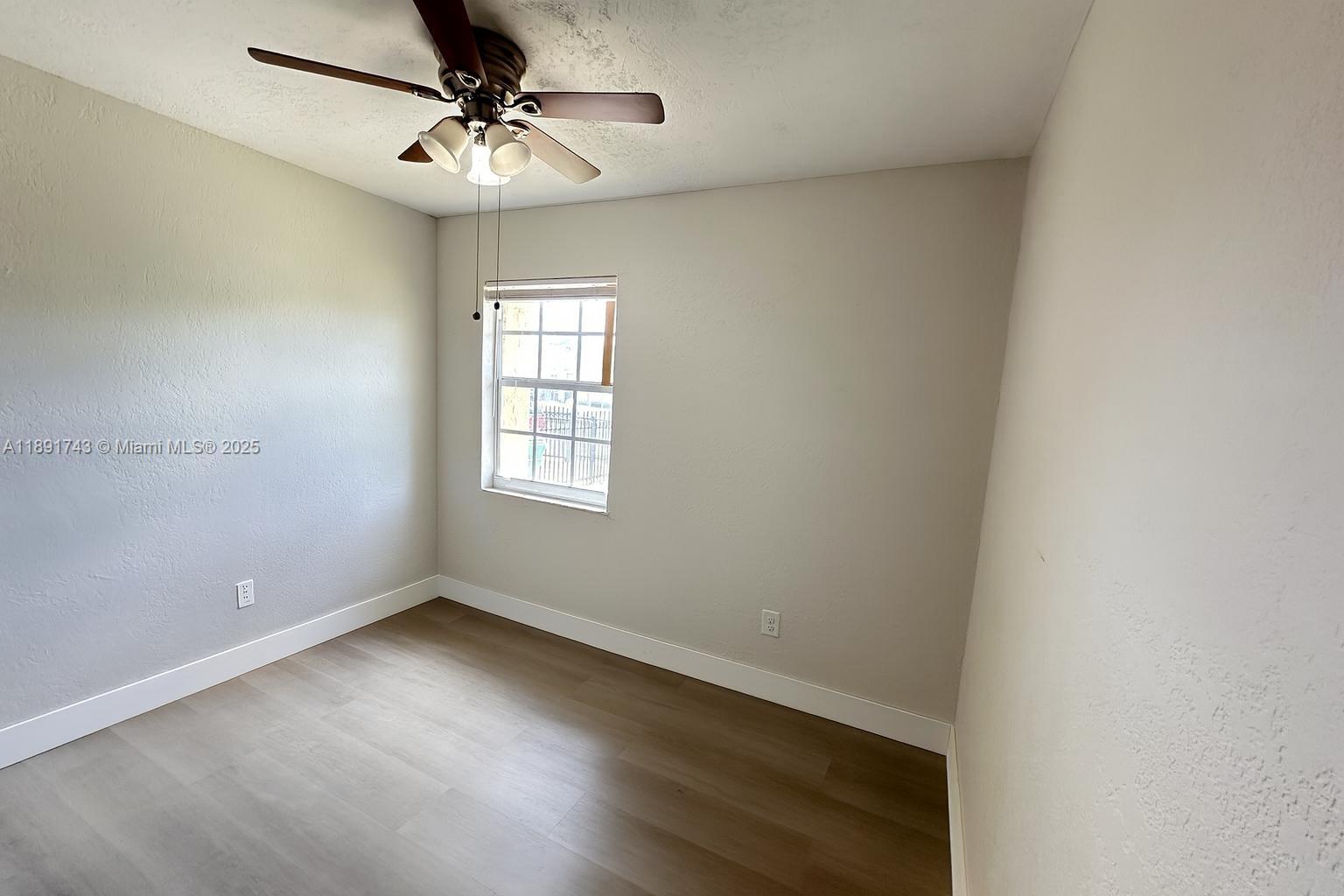 3611 Northwest 194th Terrace Miami Gardens, FL 33056 - Photo 9 of 15 an empty room with a window and a fan