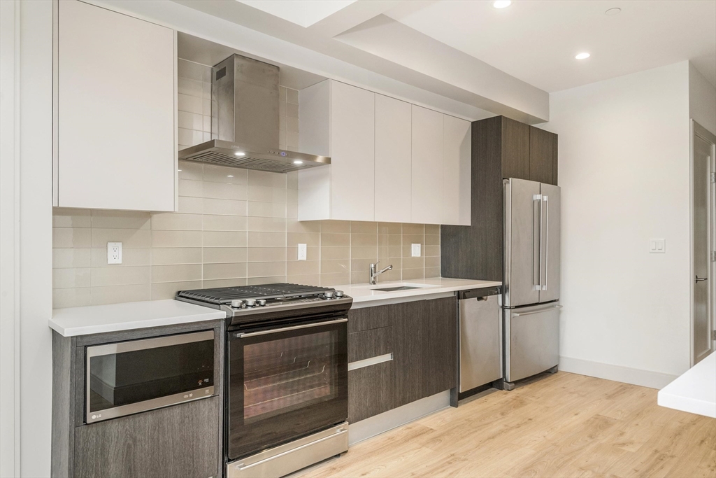178 St Alphonsus Street, Unit 1 Boston, MA 02120 - Photo 2 of 8 a kitchen with stainless steel appliances a stove a microwave and a refrigerator