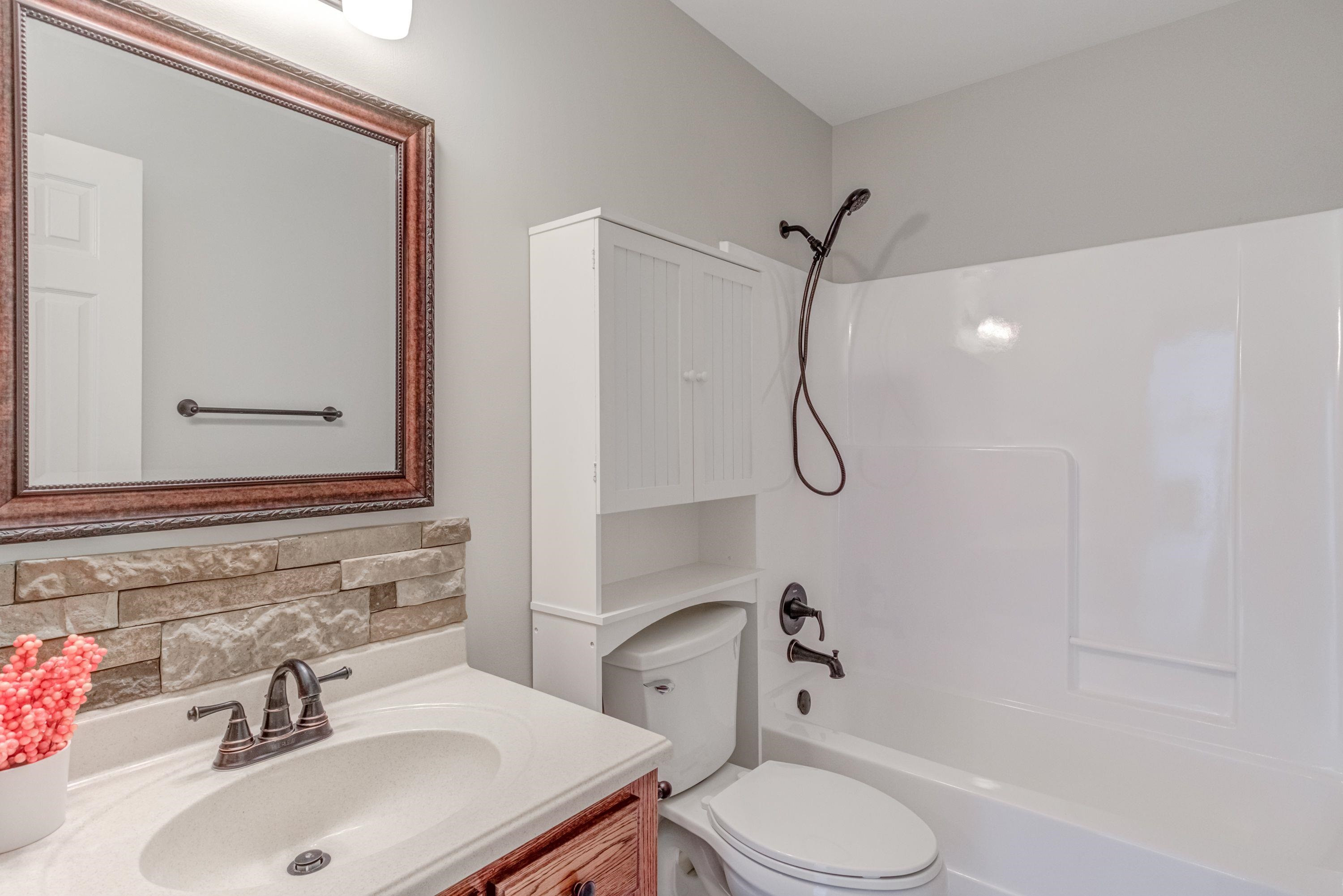 9305 Tallgrass Road Raleigh, NC 27603 - Photo 26 of 49 Updated counter/sink/faucet/mirror/lighting, newer commode and reglazed tub! Tiled floor! Main Bathroom