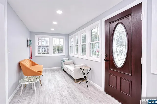 a living room with furniture a front door mirror and a window