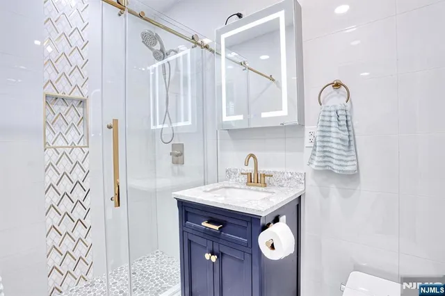 a bathroom with a sink a mirror a vanity and shower