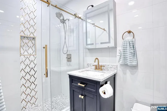 a bathroom with a sink a mirror a vanity and shower