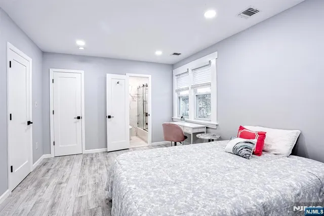 a bedroom with a large bed and wooden floor