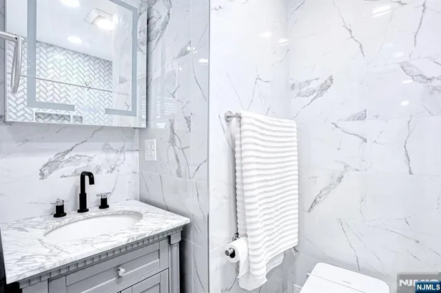 a bathroom with a granite countertop sink and a mirror