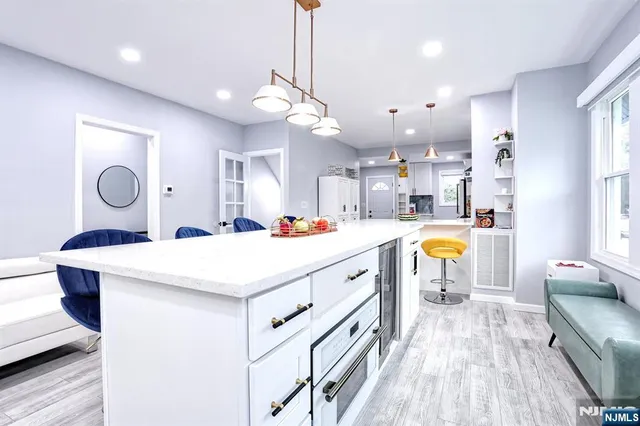 a large white kitchen with wooden floor