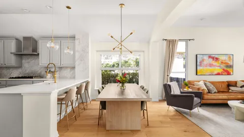 a living room with furniture a large window and a table