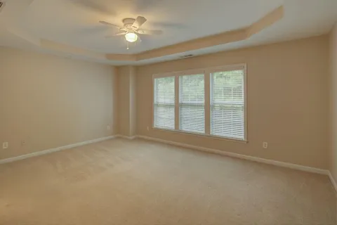 an empty room with a fan & a window
