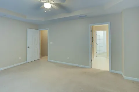 an empty room with windows and ceiling fan