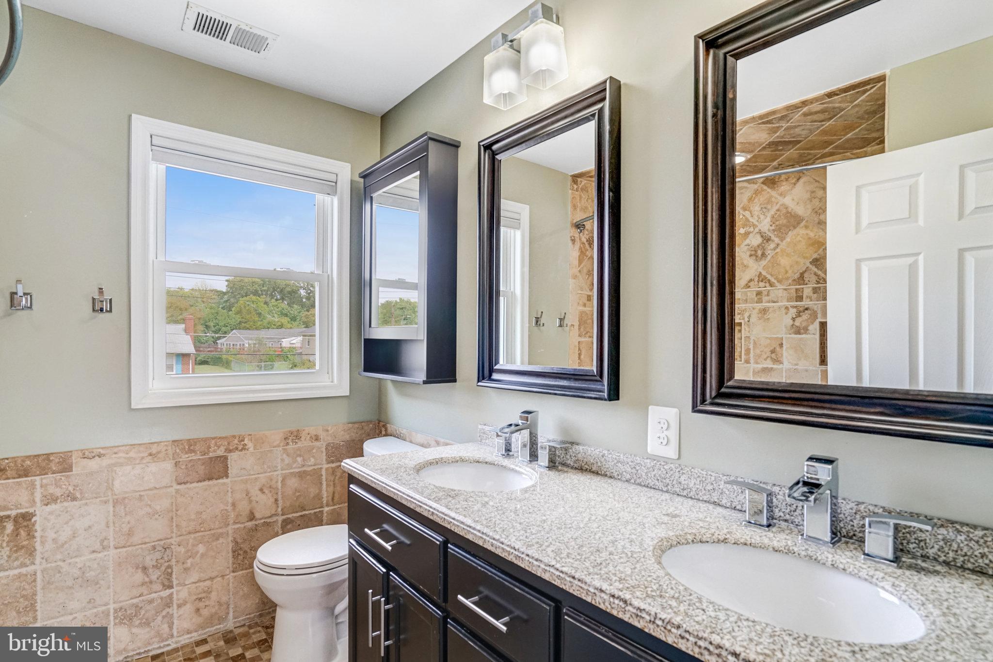 5227 Cather Road Springfield, VA 22151 - Photo 36 of 72 a bathroom with a granite countertop sink toilet and mirror