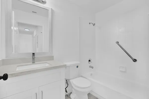 a bathroom with a sink toilet vanity and bathtub