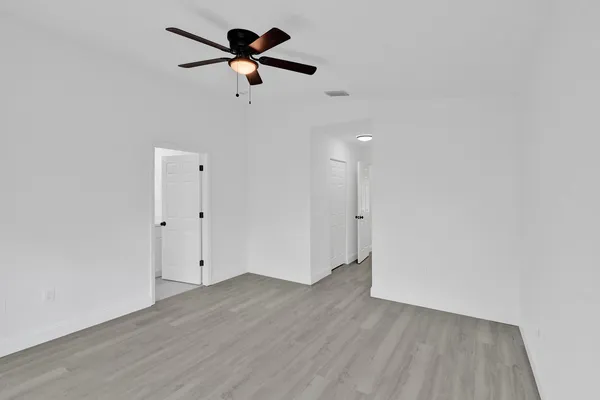 a view of a room with wooden floor and ceiling fan