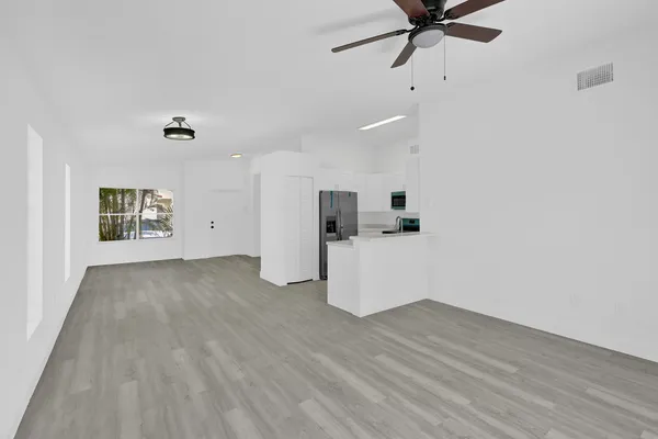 a view of a room with wooden floor and white walls