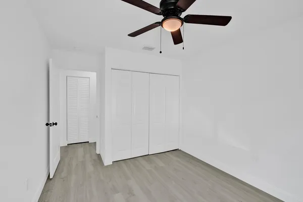 an empty room with a ceiling fan and carpet