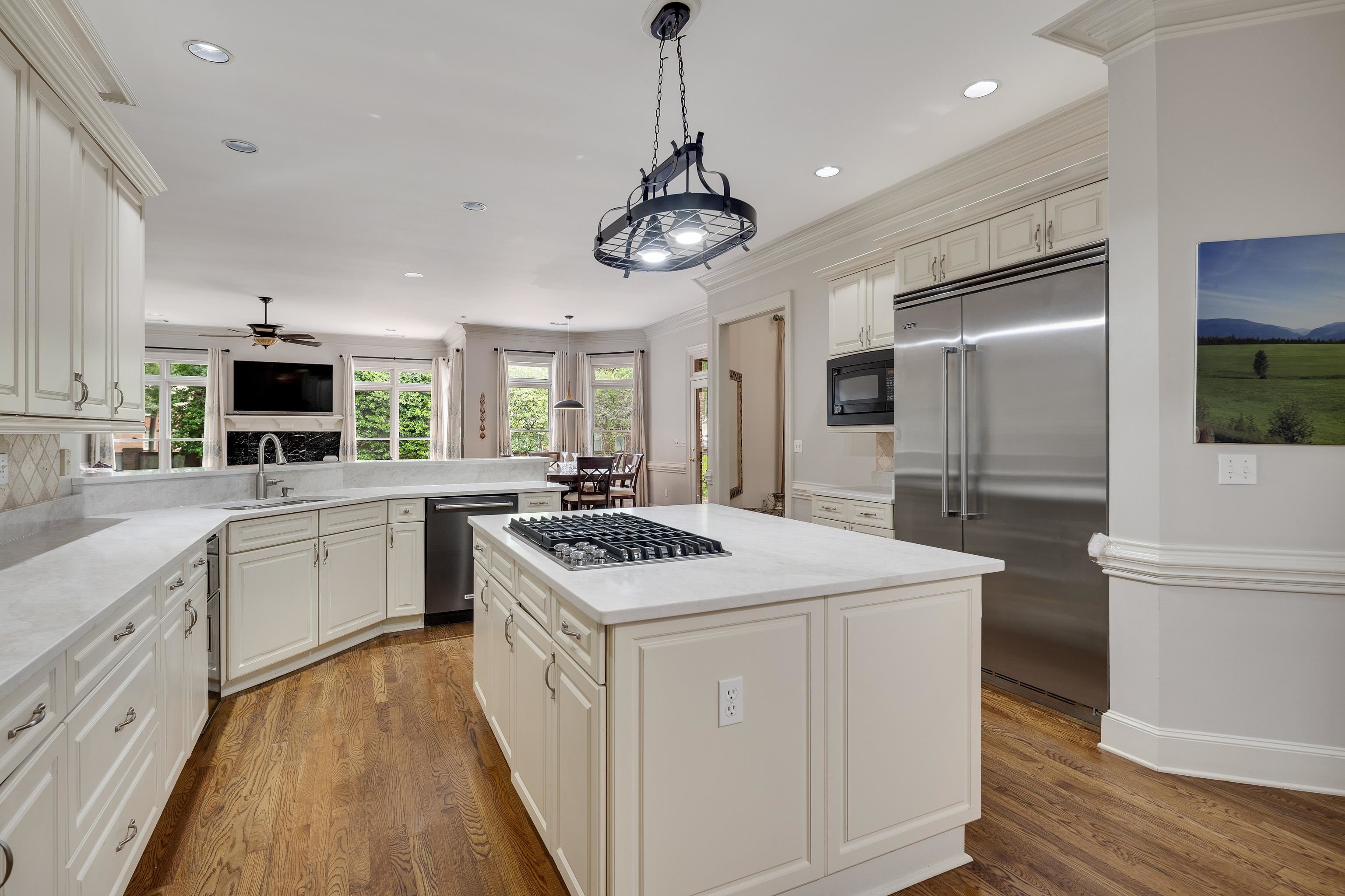 350 Bluff Ridge Cove Memphis, TN 38018 - Photo 17 of 37 Gourmet kitchen featuring a central island with gas cooktop, recessed and pendant lighting, stainless steel appliances, white cabinetry, and wood-finish flooring