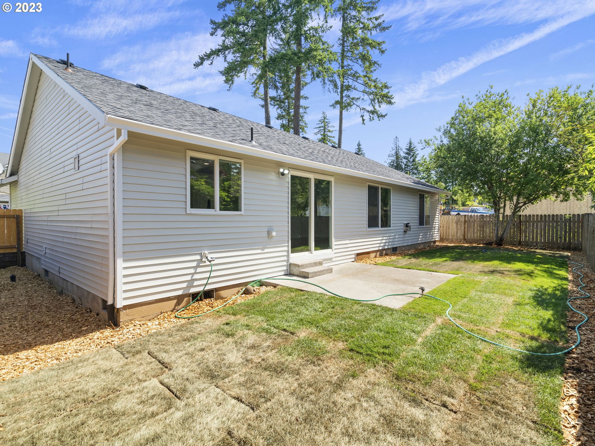 15268 Penny Avenue Sandy, OR 97055 - Photo 32 of 35 a view of a white house with a small yard and a large tree