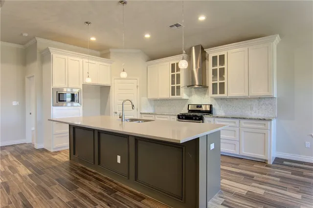 a kitchen with stainless steel appliances granite countertop a sink stove and cabinets