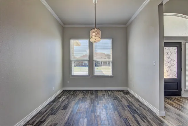 a view of a room with wooden floor exposed radiator and windows
