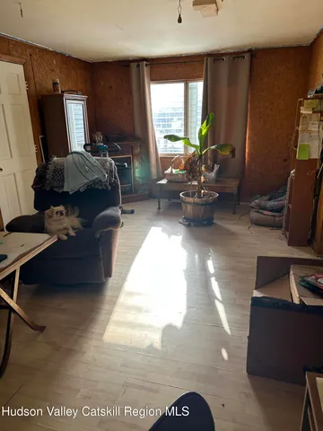 a living room with furniture a window and a flat screen tv