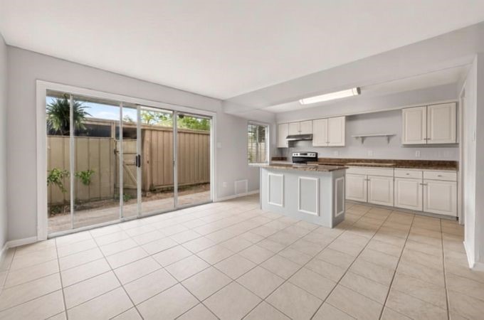 6404 Burgoyne Road, Unit 159 Houston, TX 77057 - Photo 18 of 38 Bright and spacious kitchen with sleek tile flooring, modern cabinetry, and ample natural light from large sliding glass doors leading to a private outdoor area