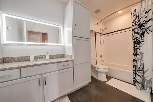 a bathroom with a granite countertop sink toilet and shower