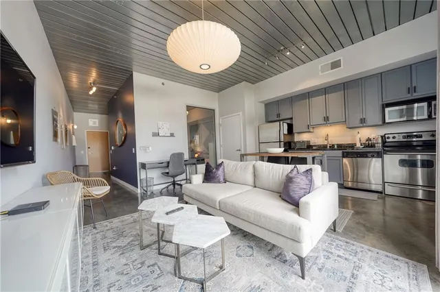 a living room with furniture and kitchen view