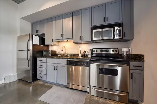 a kitchen with stainless steel appliances granite countertop a stove and a microwave