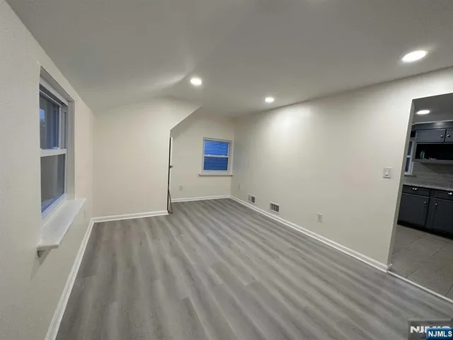 a view of empty room with wooden floor