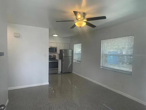 a view of a livingroom with a ceiling fan and window