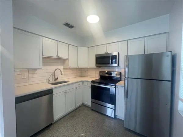 a kitchen with a sink appliances and cabinets