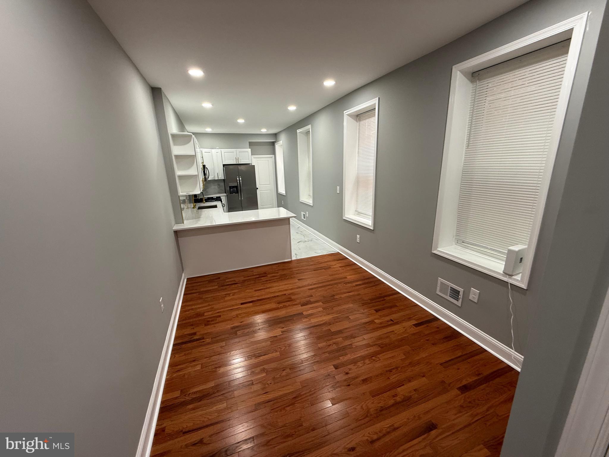 2122 West Toronto Street Philadelphia, PA 19132 - Photo 11 of 112 a view of kitchen and empty room with wooden floor
