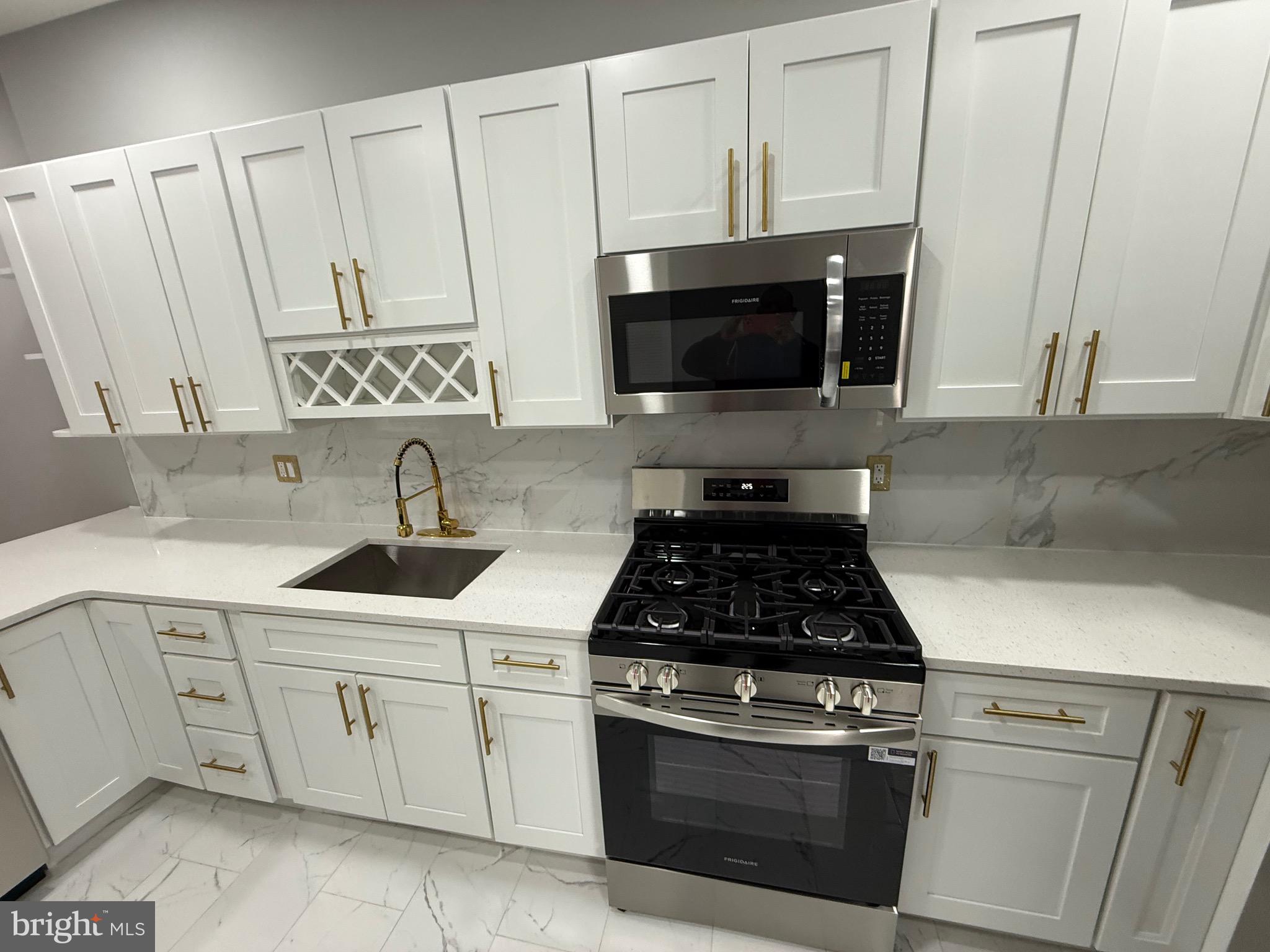 2122 West Toronto Street Philadelphia, PA 19132 - Photo 17 of 112 a kitchen with white cabinets and appliances