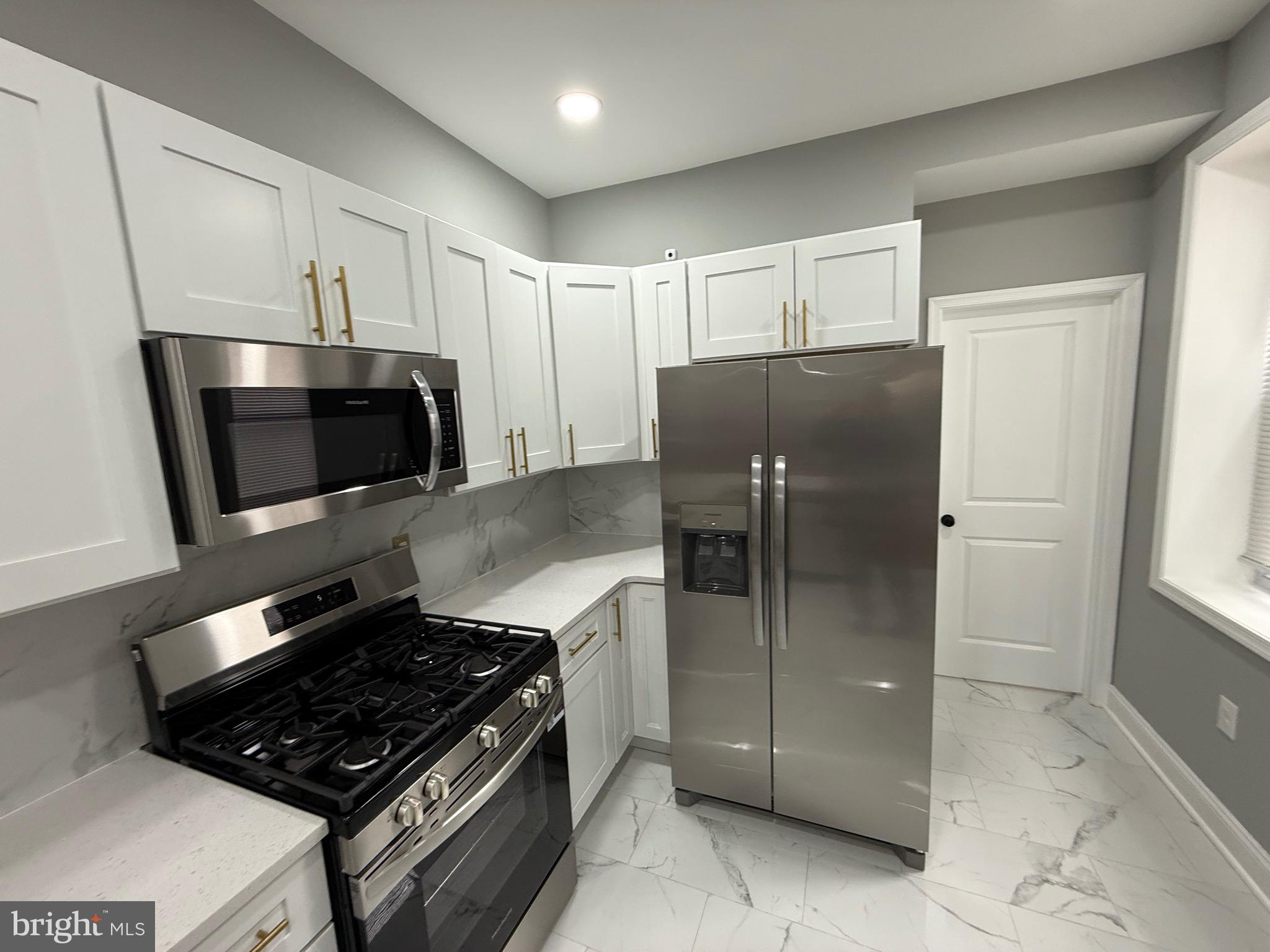2122 West Toronto Street Philadelphia, PA 19132 - Photo 20 of 112 a kitchen with stainless steel appliances granite countertop a refrigerator and a stove