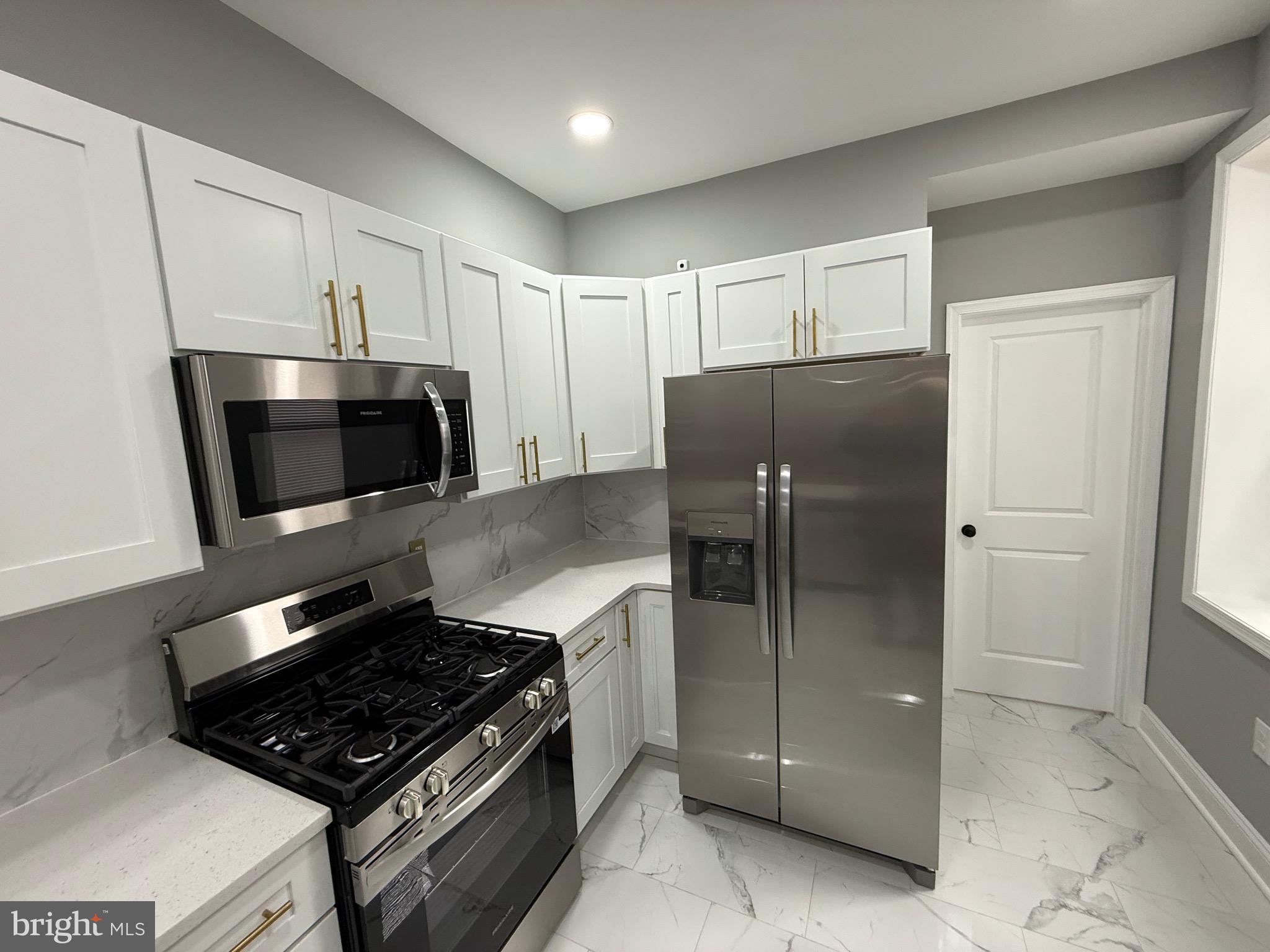 2122 West Toronto Street Philadelphia, PA 19132 - Photo 21 of 112 a kitchen with stainless steel appliances granite countertop a refrigerator and a stove