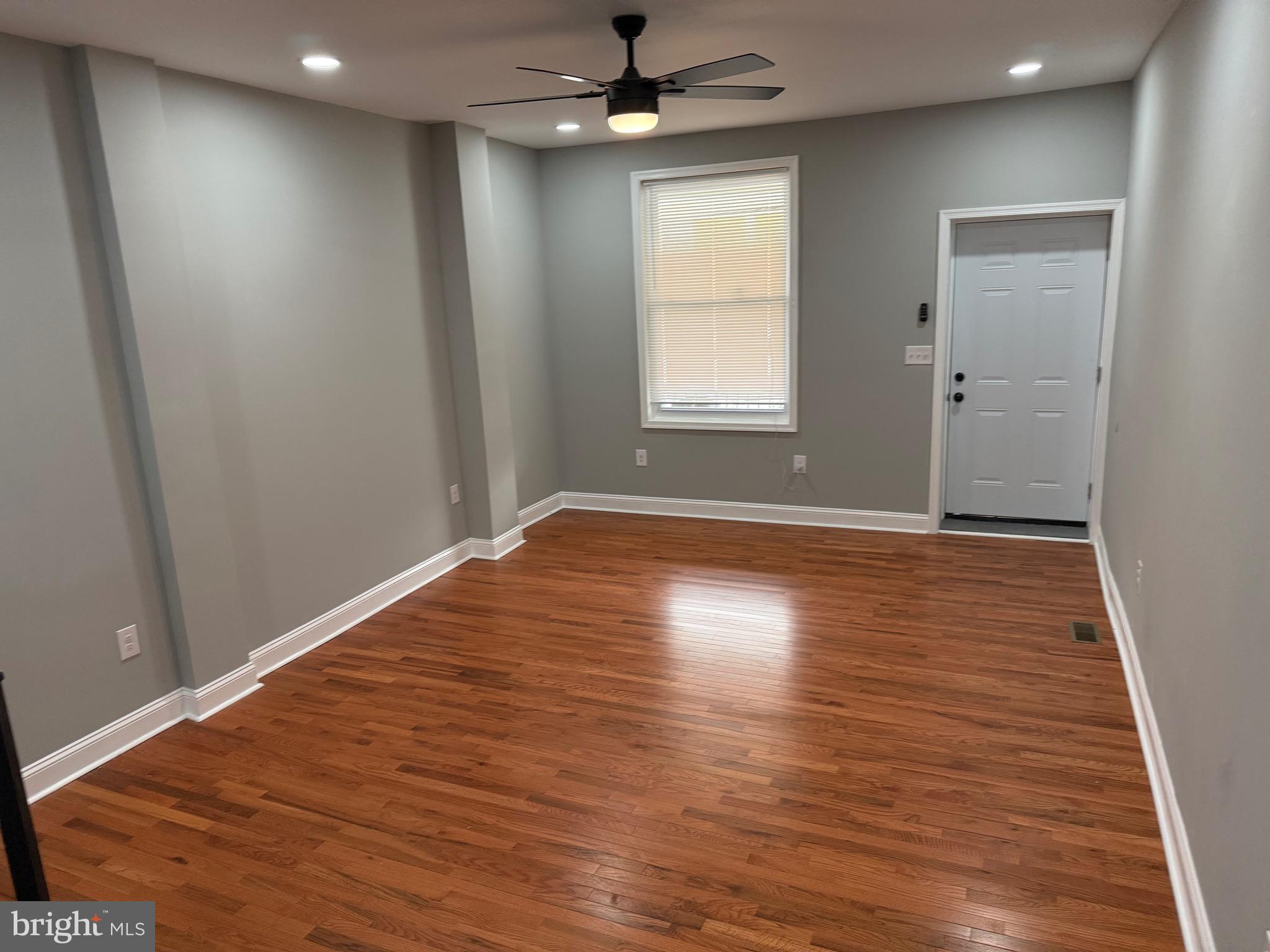 2122 West Toronto Street Philadelphia, PA 19132 - Photo 7 of 112 an empty room with wooden floor ceiling fan and windows