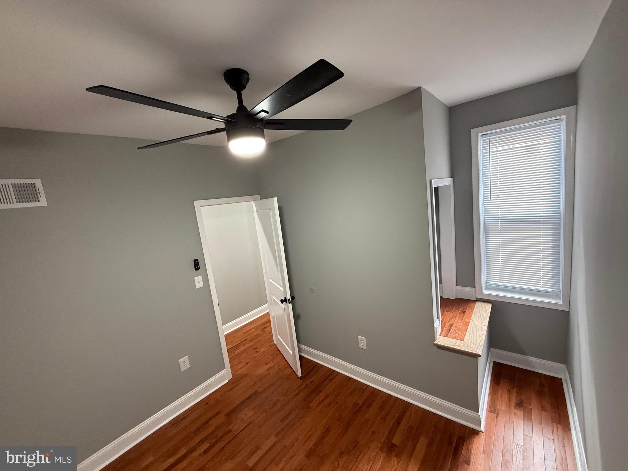 2122 West Toronto Street Philadelphia, PA 19132 - Photo 80 of 112 an empty room with wooden floor and a ceiling fan