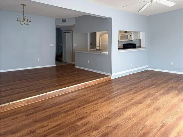 a view of a kitchen with wooden floor and a refrigerator