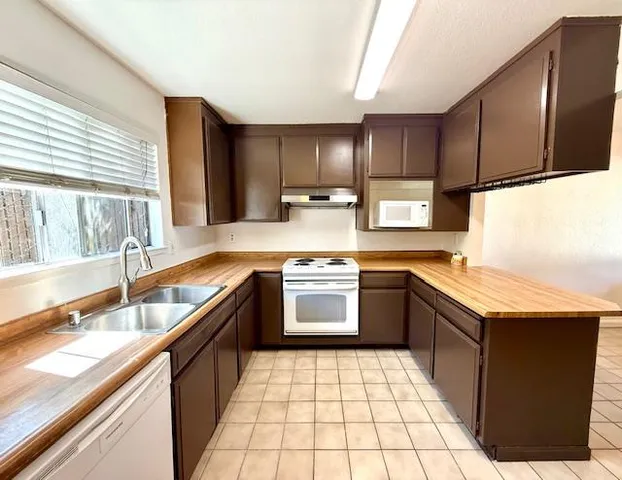 a kitchen with a stove sink and cabinets