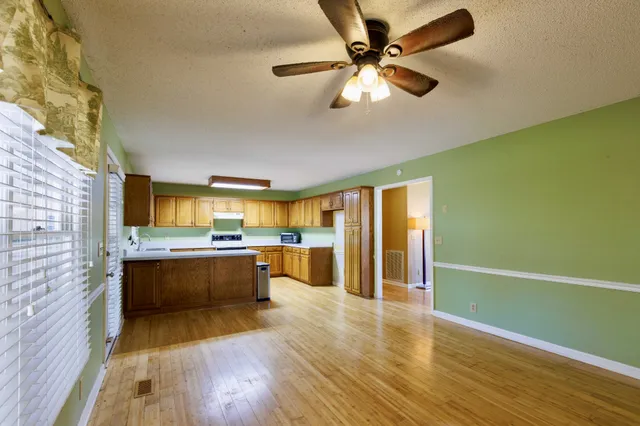 a view of a kitchen with a sink and dishwasher with wooden floor