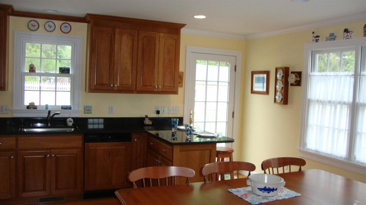 44 Longell Road Dennis Port, MA 02639 - Photo 29 of 35 a kitchen with granite countertop a stove a sink dishwasher and cabinets with wooden floor