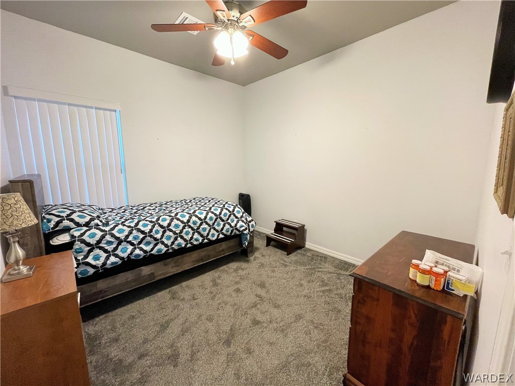 3605 North Kenneth Road Kingman, AZ 86409 - Photo 14 of 28 a bedroom with a bed and a chandelier