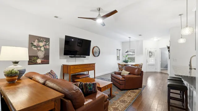 a living room with furniture a flat screen tv and kitchen view