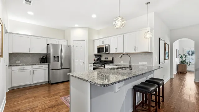 a kitchen with stainless steel appliances granite countertop a sink refrigerator and cabinets