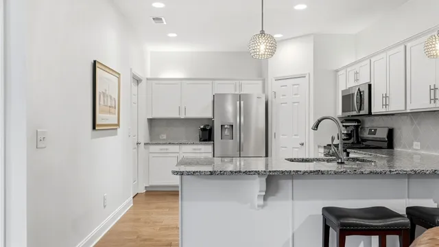 a kitchen with stainless steel appliances granite countertop a refrigerator sink and cabinets